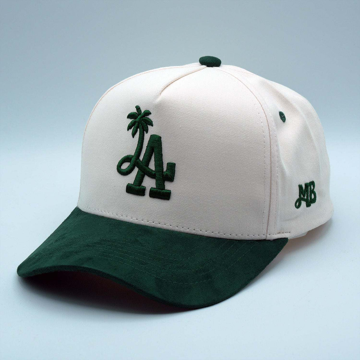 LA Palm Tree snapback cap with a white cotton crown, dark green suede brim, and raised embroidered palm tree logo.