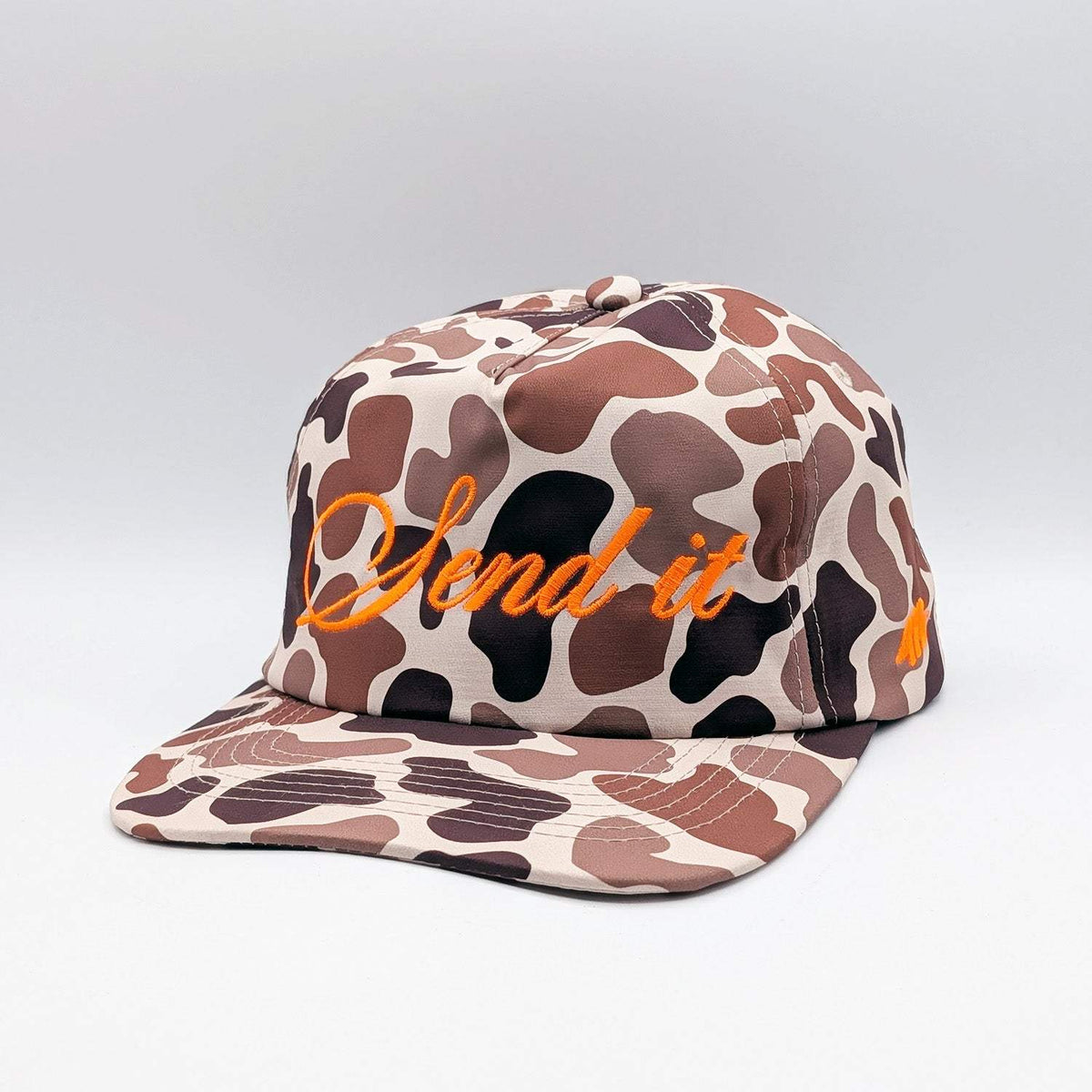 SEND IT Snapback in brown, cream, and black camouflage fabric, with orange embroidered script and a flat brim.