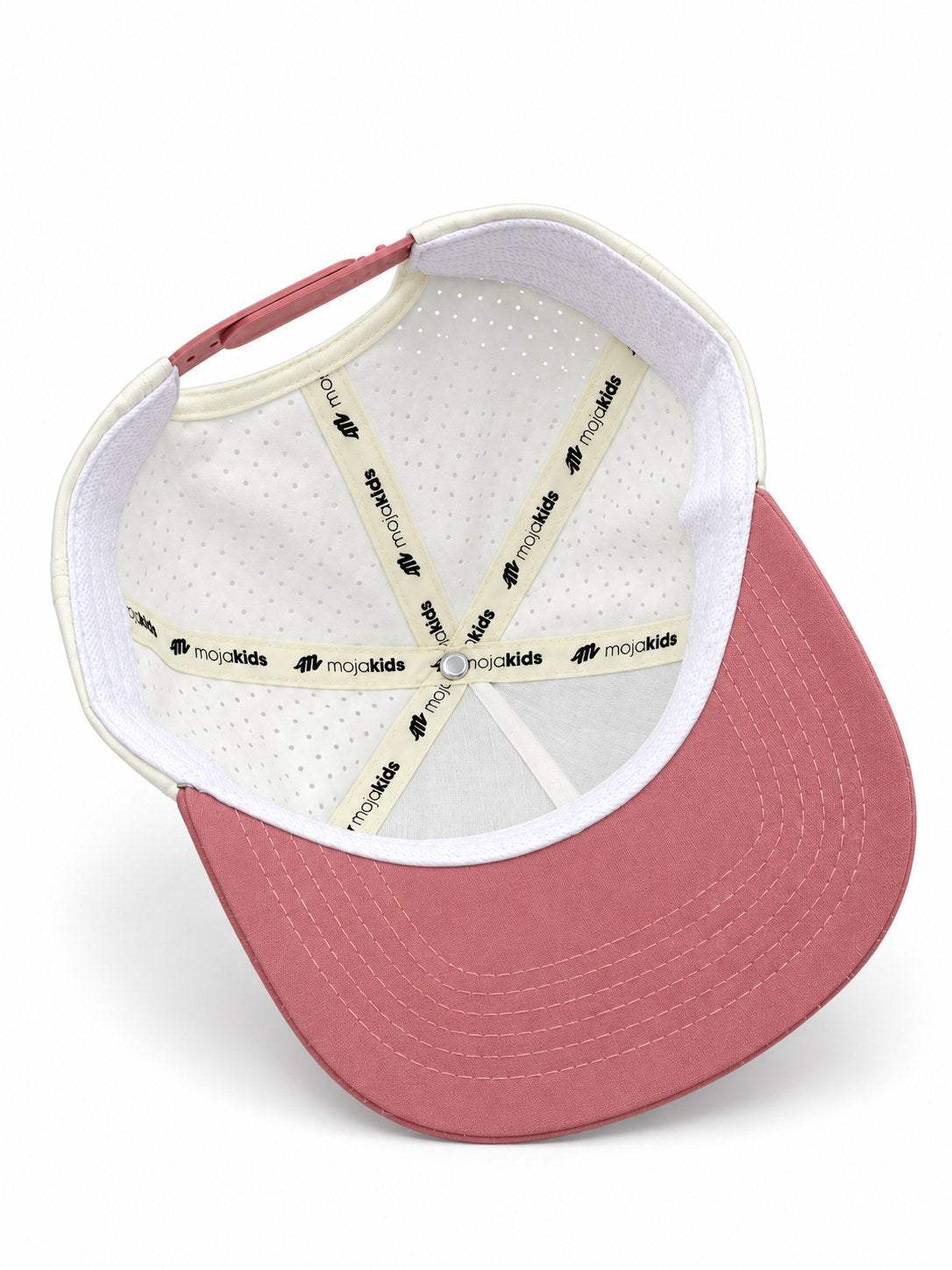 Ivory and dusty pink MOJA Kids cap interior showing branded seam tape and laser-cut ventilation