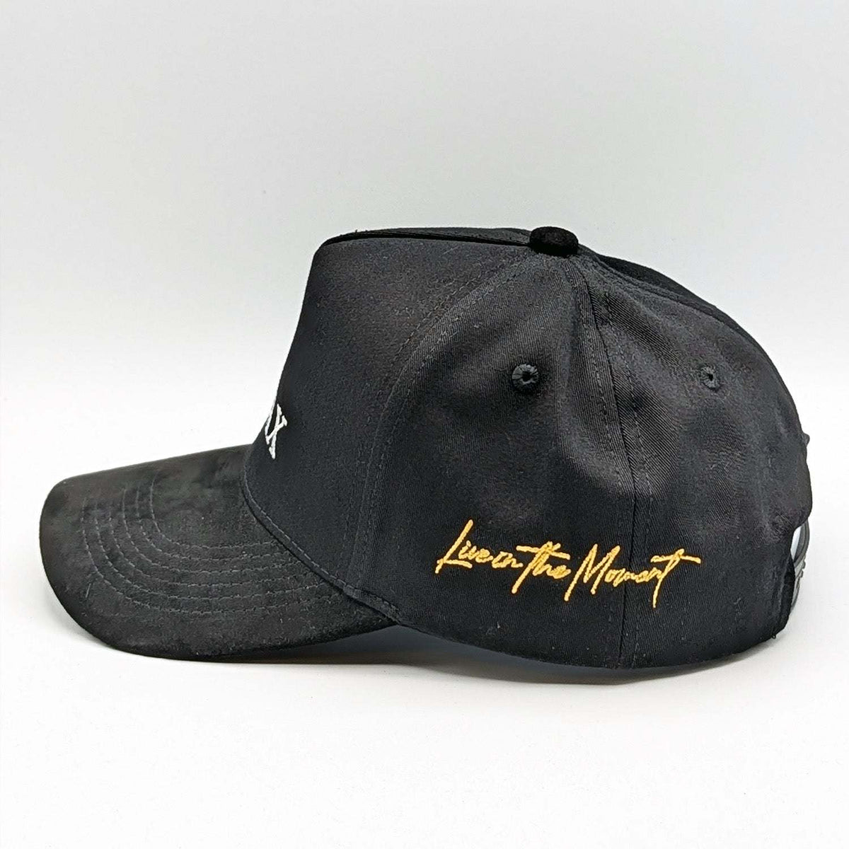 Relax - Premium Suede Snapback Hat in black suede-like fabric with a curved brim and gold “Live in the Moment” embroidery